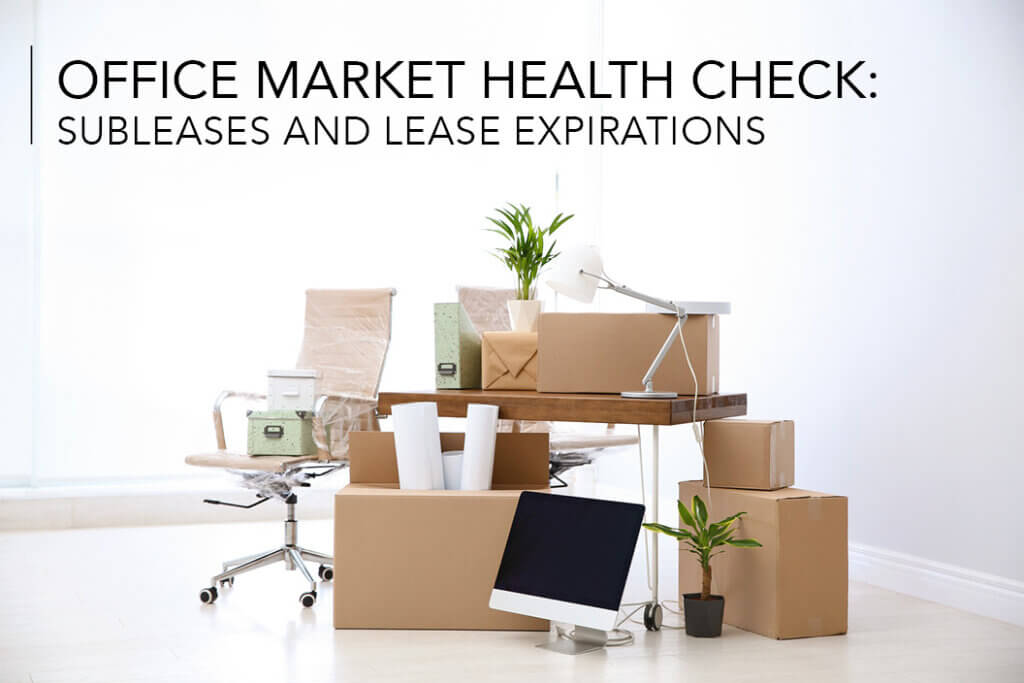 An office desk, chair and lamp with moving boxes